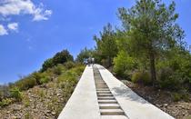 A concrete corridor, with steps and ramps, leads to the top of the trail.